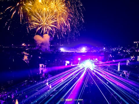 Gold fireworks burst over purple lasers and the crowd on New Year's Eve with Marshmello at Armature Works, Tampa, 2023