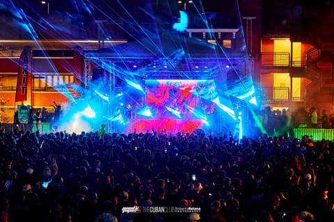 Blue lasers sweep over a packed crowd at Dom Dolla's outdoor stage show at The Cuban Club, Ybor City, April 2023